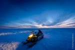 A skidoo with a beautiful, cold, Antarctic skies above